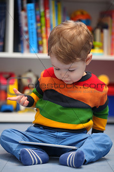 Happy 2 years old boy using a digital tablet computer