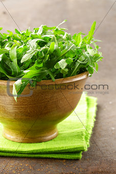 fresh green salad arugula in a wooden bowl