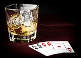 poker playing cards near wiskey glass