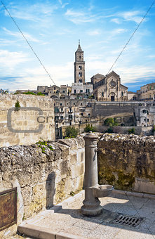 panoramic view of tipical water dispenser and church of Matera under blue sky