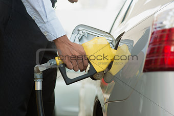 Pumping gasoline fuel at gas station