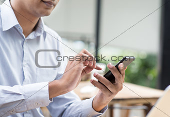 Indian businessman using smartphone while having lunch 