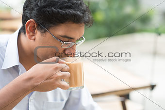 Indian businessman sipping a cup hot milk tea 