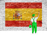 House painter paints flag of Spain on brick wall