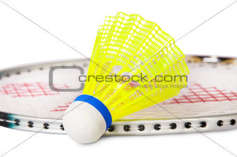 One shuttlecock lying near the badminton racket