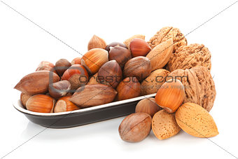 Various nuts in bowl isolated on white.