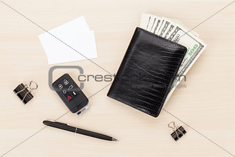Money cash wallet and car remote key on wooden table