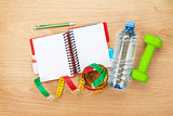 Dumbells, tape measure, water bottle and notepad for copy space