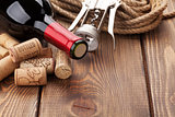 Red wine bottle, heap of corks and corkscrew