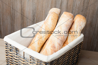 Loafs of traditional French bread baguette stocked in woven bask