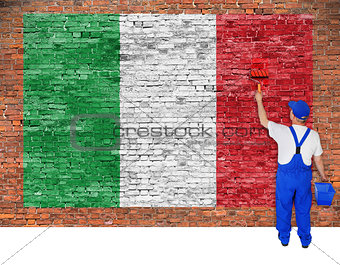 House painter paints flag of Italy on brick wall