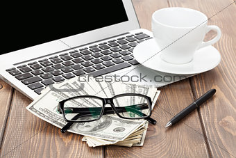Office table with pc, coffee cup, glasses and money