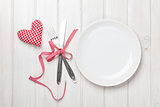 Empty plate, silverware and valentines day heart shaped toy