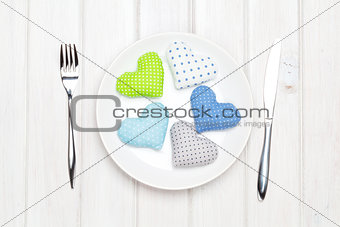 Valentines day toy hearts on plate and silverware