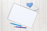 Blank paper, pencils and valentines day heart shaped toys on the