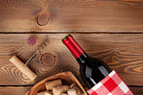 Red wine bottle, bowl with corks and corkscrew. View from above