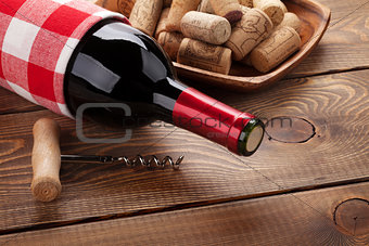 Red wine bottle, bowl with corks and corkscrew