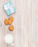 Cup of milk, heart shaped cookies and gift box