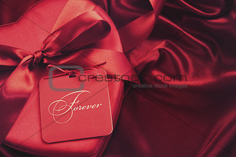 Chocolate box with gift card on satin background