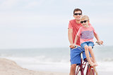 family biking at the beach