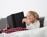 Laughing Young Girl Reading a book