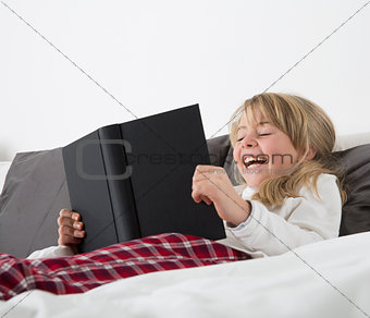 Laughing Young Girl Reading a book