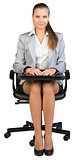 Businesswoman on office chair, holding closed laptop
