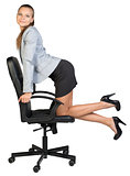 Businesswoman kneeling on office chair, looking at camera cheerfully