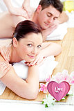 Composite image of relaxed young couple receiving a back massage