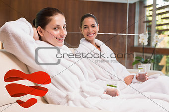 Composite image of smiling women in bathrobes sitting on couch