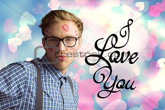 Composite image of geeky hipster covered in kisses