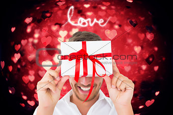 Composite image of man holding gift