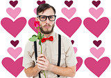 Composite image of geeky hipster offering a rose
