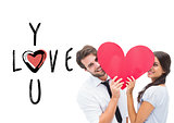 Composite image of couple smiling at camera holding a heart