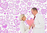Composite image of older affectionate couple holding pink heart shape