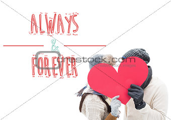 Composite image of attractive young couple in warm clothes holding red heart