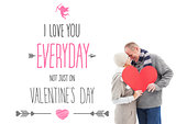 Composite image of happy mature couple in winter clothes holding red heart