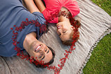 Composite image of two friends looking towards the sky while lying on a quilt