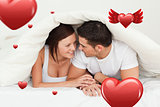 Composite image of happy couple hiding under a blanket