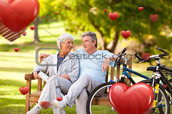 Composite image of elderly couple with their bikes