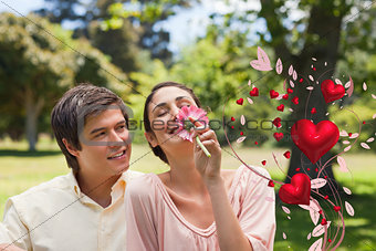 Composite image of man watching his friend while she is smelling a flower