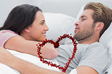 Composite image of couple awaking and looking at each other