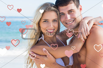 Composite image of beautiful couple hugging and smiling