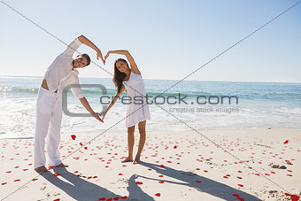 Composite image of loving couple forming heart shape with arms