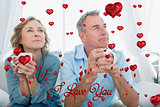 Composite image of thoughtful middle aged couple sitting on the couch having coffee