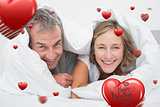 Composite image of happy middle aged couple under the duvet
