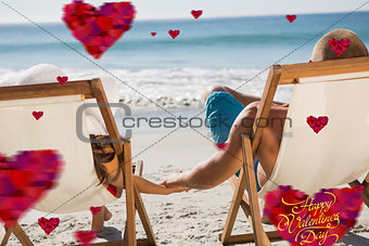 Composite image of cute couple holding hands while lying on their deck chairs