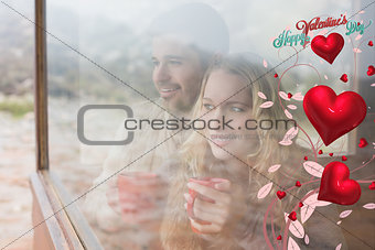 Composite image of thoughtful content couple with cups looking through window