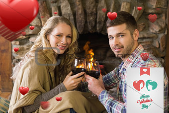 Composite image of romantic couple toasting wineglasses in front of lit fireplace