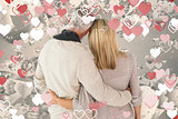 Composite image of happy couple standing with arms around
